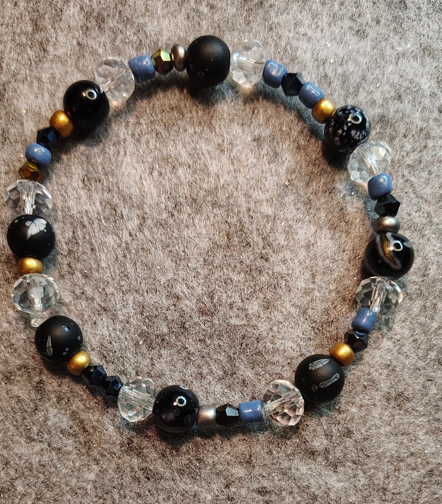 Handmade stretchy bracelet. Black, blue, gold, silver & clear beads